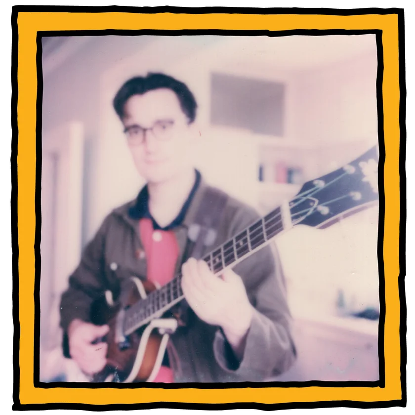 Blurred polaroid-style photo of Ed playing a bass guitar, in an orange and black frame
